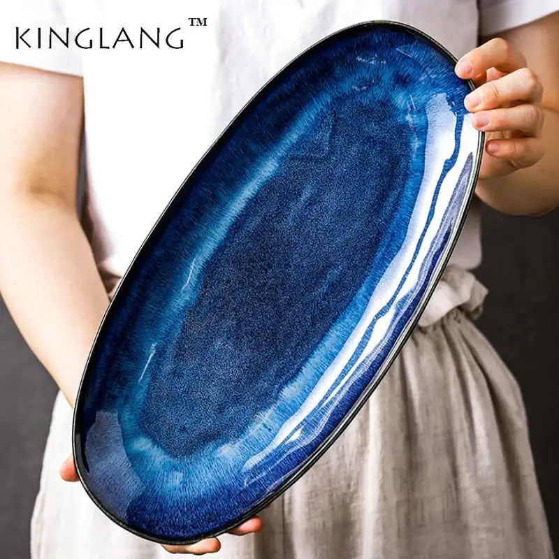 A sleek blue kiln glazed oval ceramic sushi plate with gradient navy blue glaze and glossy finish by decorbites