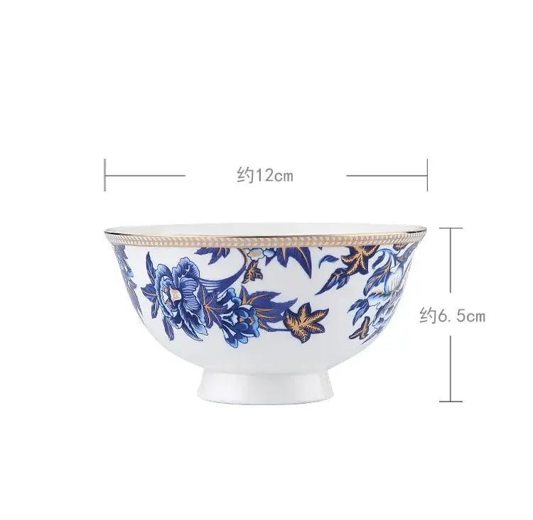 A white ceramic bowl with blue and gold floral patterns and a golden rim from decorbites blue lotus dinnerware set