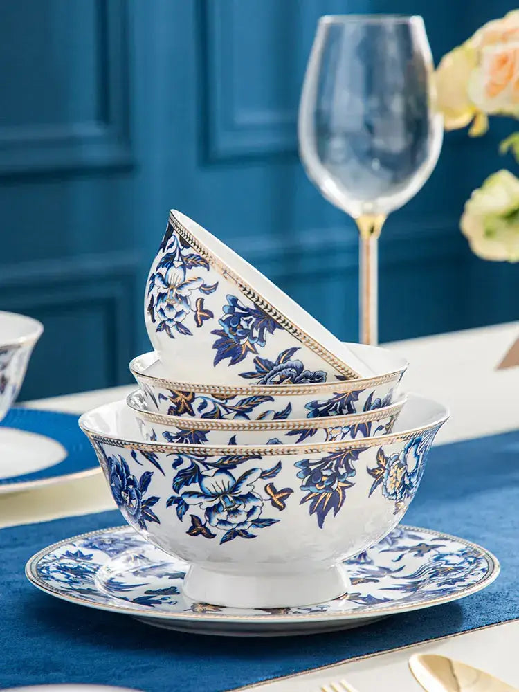 Stacked blue lotus dinnerware ceramic bowls with intricate blue floral patterns and gold rims on matching plate decorbites blue lotus