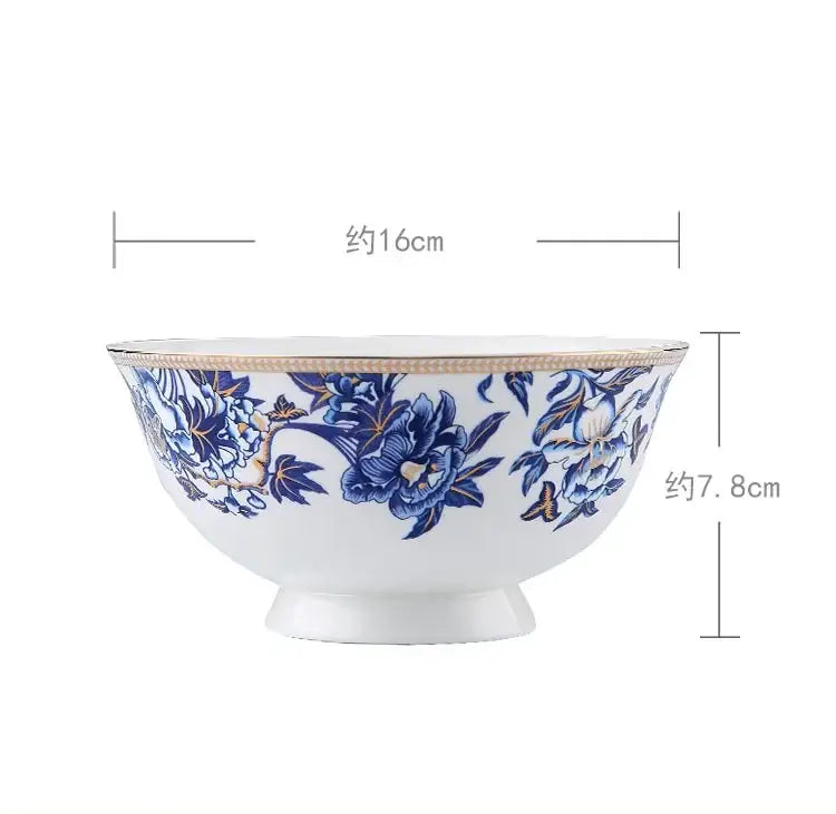 A white ceramic bowl with intricate blue floral patterns and gold rim from decorbites blue lotus dinnerware set