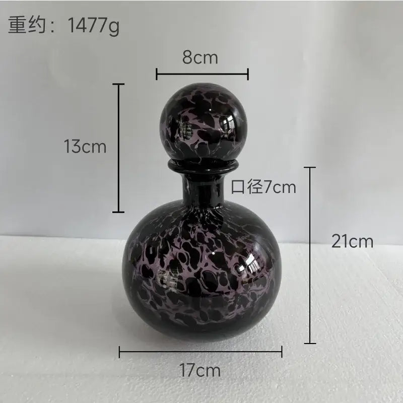 A black glass decanter with a blue marbled leopard print stopper for decorbites leopard print glass vase decor