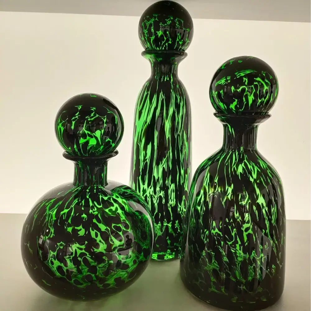 Three elegant glass decanters with vibrant green and black marbled leopard print glass decorbites living room decor