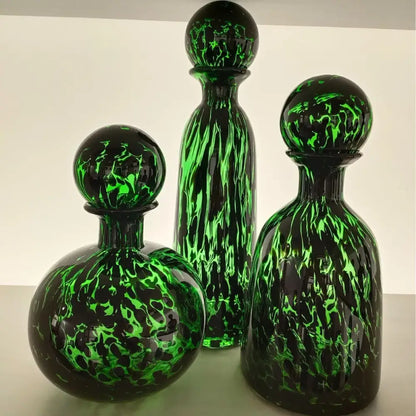 Three elegant glass decanters with vibrant green and black marbled leopard print glass decorbites living room decor