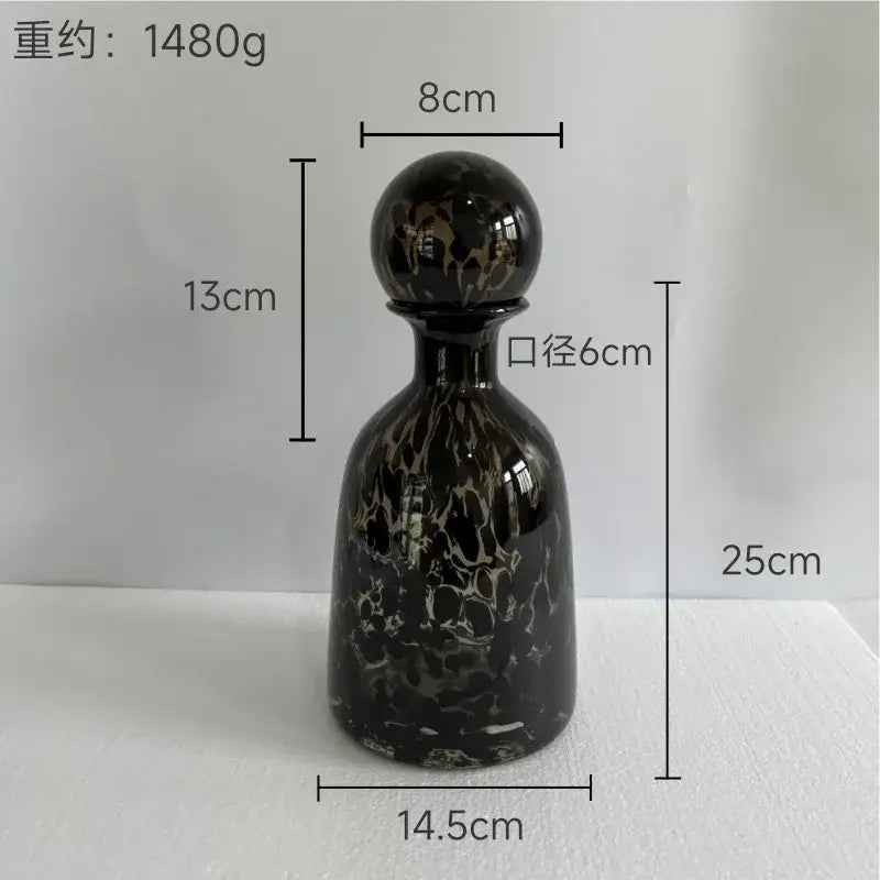 A sleek black glass decanter with white marbled pattern and stopper is a decorbites leopard print glass vase decor piece