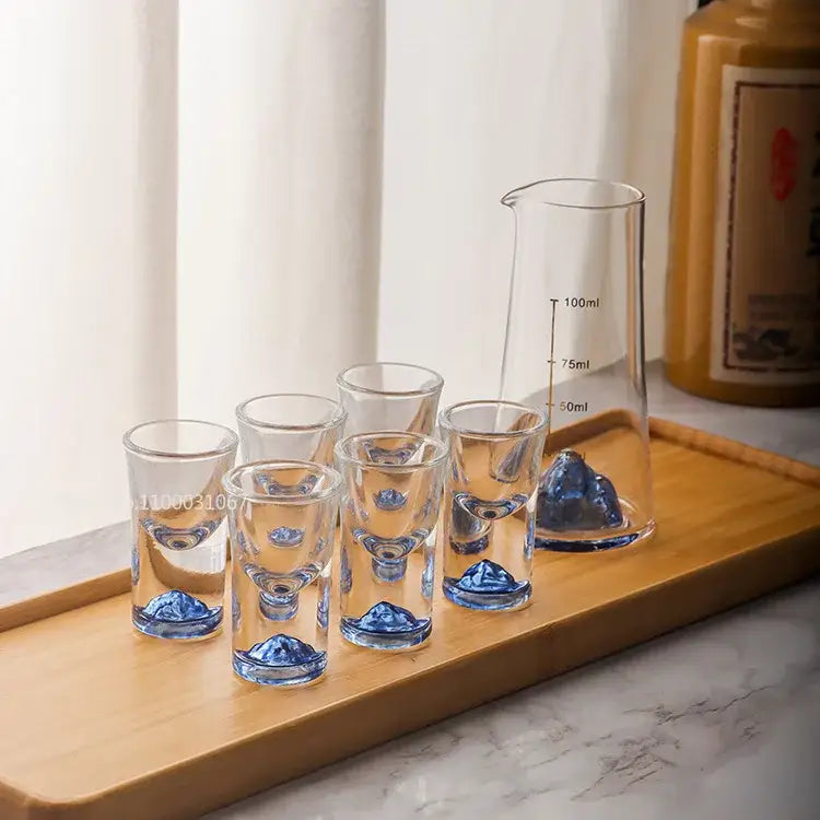 Set of clear glass decorbites blue sake glasses and matching ice jug with blue mountain design on wooden tray