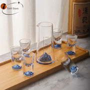 Clear glass decorbites blue sake glass set with blue mountain designs and matching sake glass ice measuring pitcher on wood tray