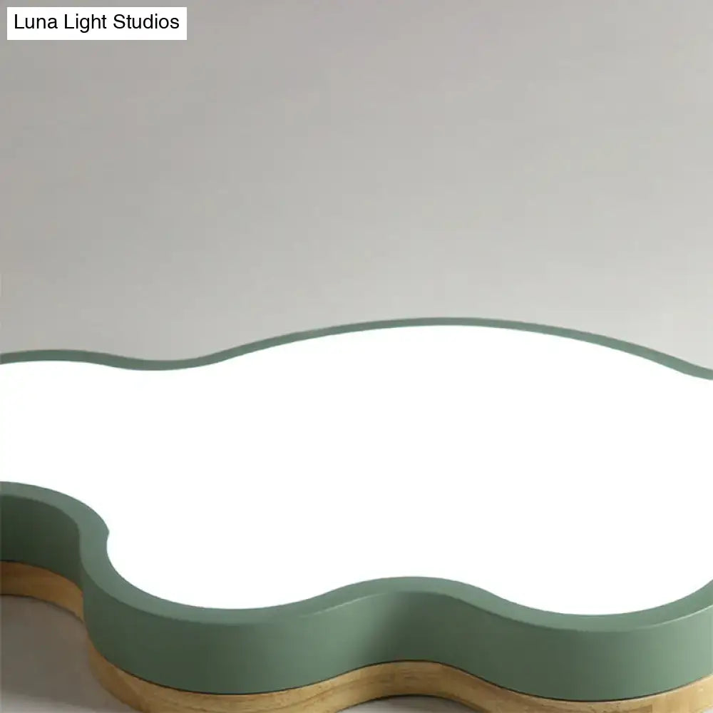 A modern cloud flush mount ceiling lamp with matte sage green frame and warm wood-toned base for kids bedroom