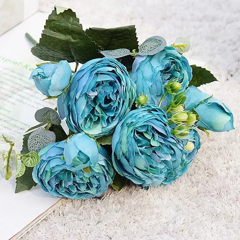 A bouquet of silk fake flowers featuring blue peony and tea rose with layered petals and lace accents for home decor