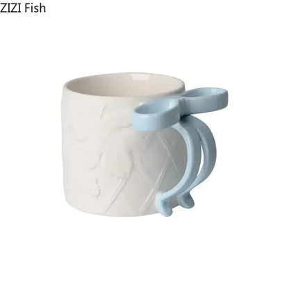 A white ceramic bowknot ceramic mug with a light blue handle and textured design from the decorbites saucer set