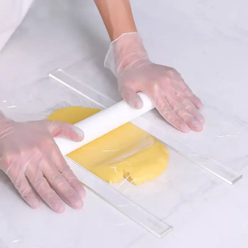 A white rolling pin flattens yellow dough inside a bag showcasing the rolling balance ruler with wood handles