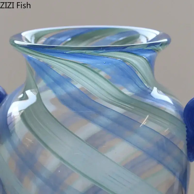 A translucent blue stripe glass vase with swirling blue and green ribbons and dark blue handles for hydroponic plants