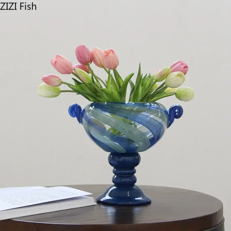 A vibrant blue stripe glass swirl vase with elegant handles holding pink and white tulips for decorbites blue stripe living room decor