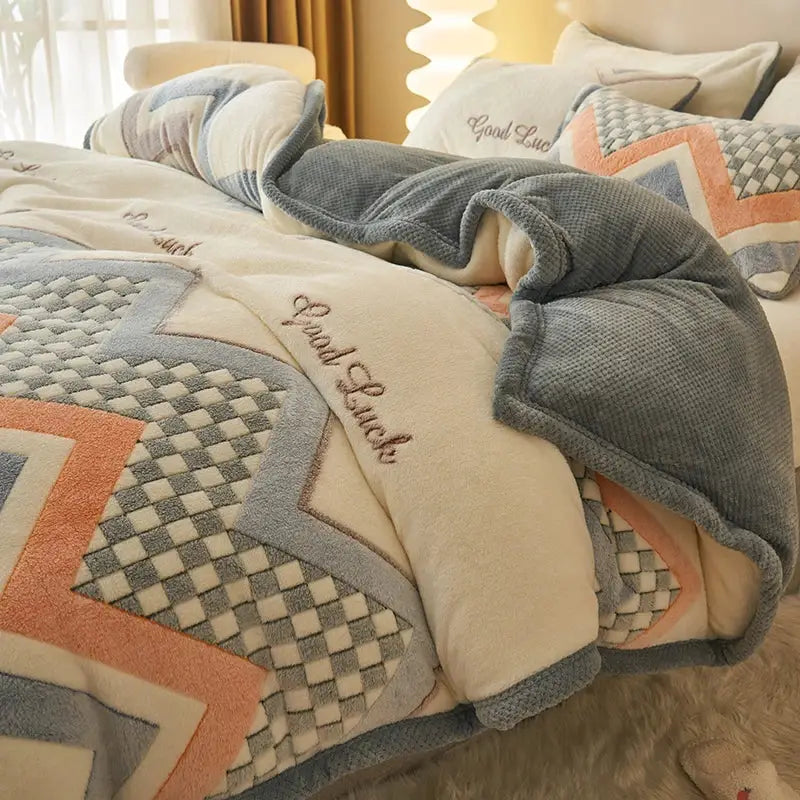 Cozy cream and gray plush quilt with geometric patterns and embroidered good luck on a winter velvet duvet cover