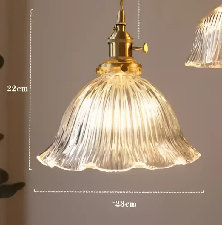 A vintage-style blue glass decorbites pendant light with brass fixture and ribbed clear shade for bedroom decor