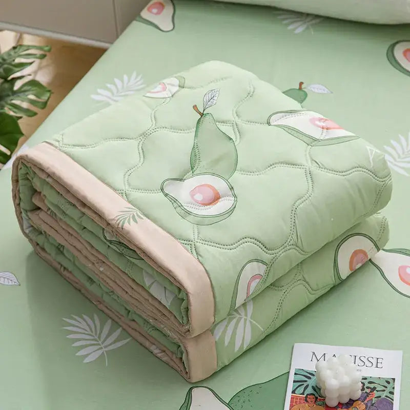 A soft light green quilted blanket with avocado and leaf pattern beige binding from decorbites daisy print quilt collection