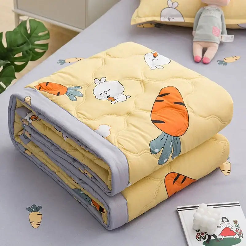 Yellow quilted blanket with cartoon carrots and bunnies and soft gray border featured in decorbites daisy print quilt collection