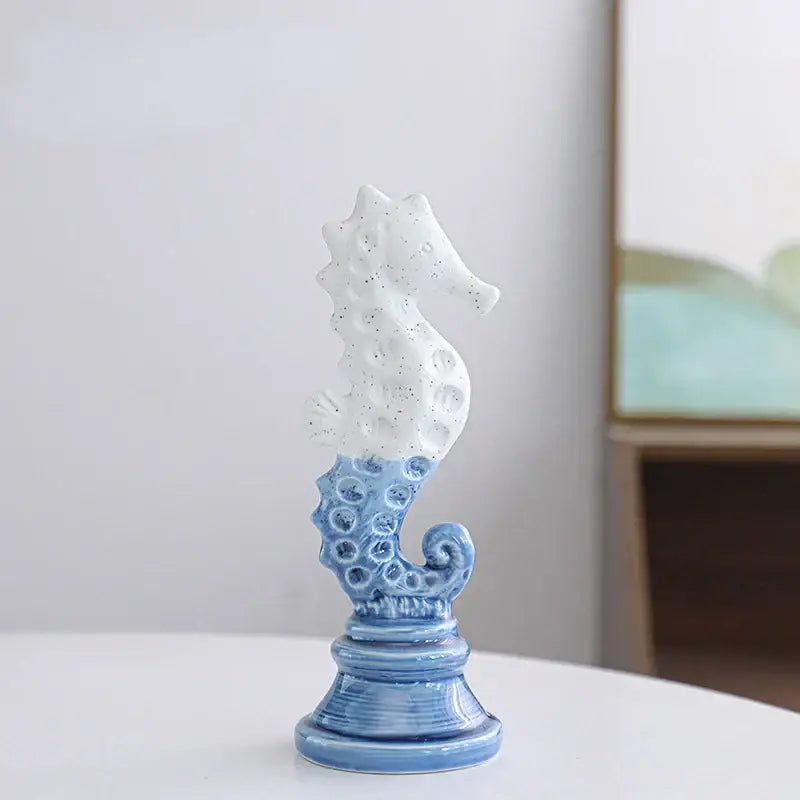 Delicate blue and white cartoon seahorse ceramic statue with speckled texture on ornate base for living room decorbites decor