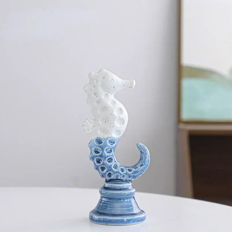 Delicate blue and white cartoon seahorse ceramic statue with speckled texture on ornate base for living room decorbites decor