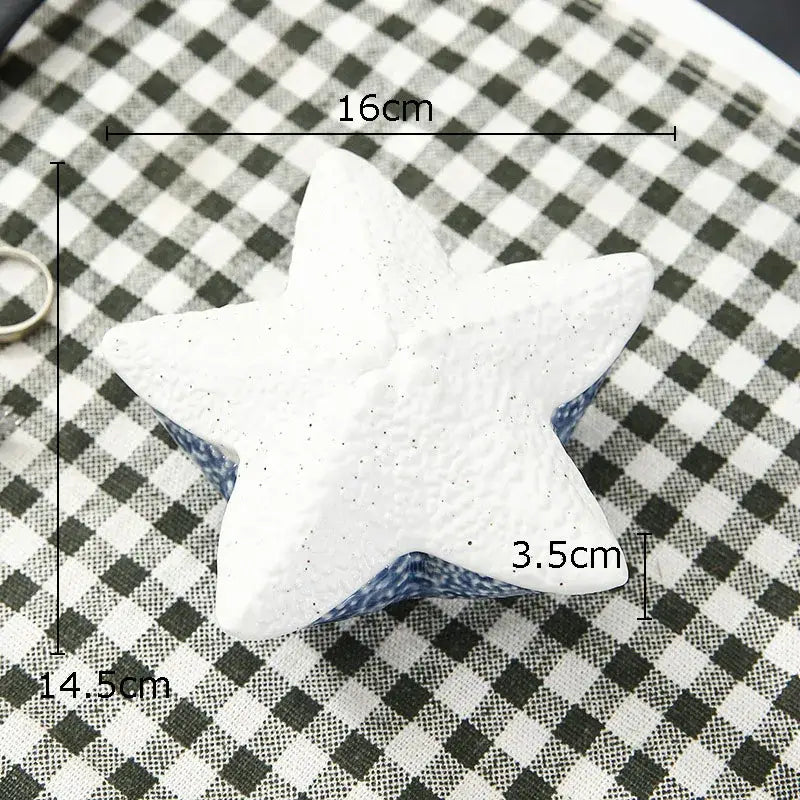 White star-shaped ceramic stress ball with speckled texture and blue base for decorbites ceramic marine life trays decor