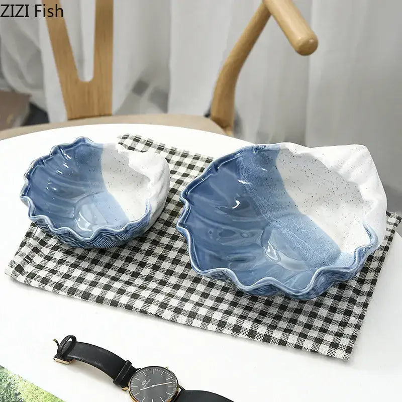 Two blue and white ceramic marine life clamshell trays with hand-painted gradient and speckled decorbites ceramic marine design