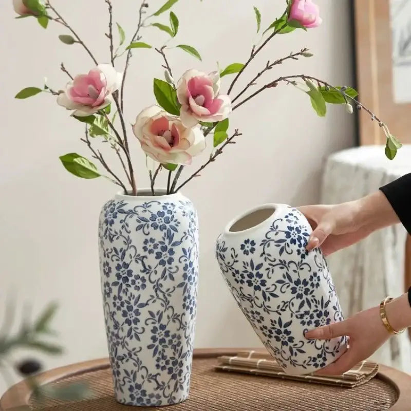 A white ceramic vase with intricate blue floral patterns featuring a smooth glaze by decorbites blue for living room decor