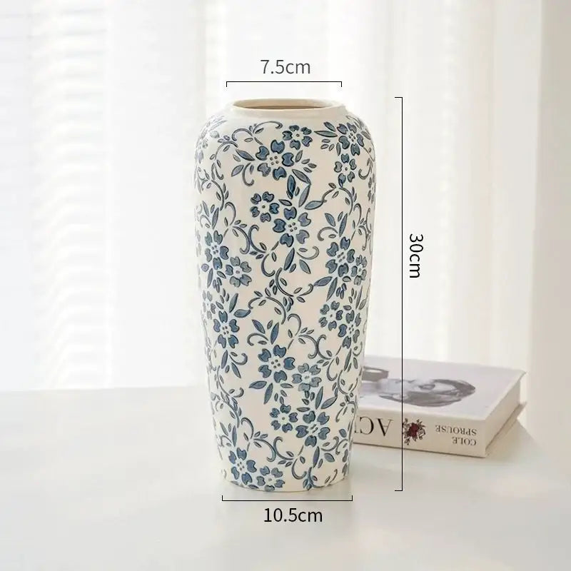 A tall slender white ceramic vase with intricate blue floral patterns decorbites blue for living room decor