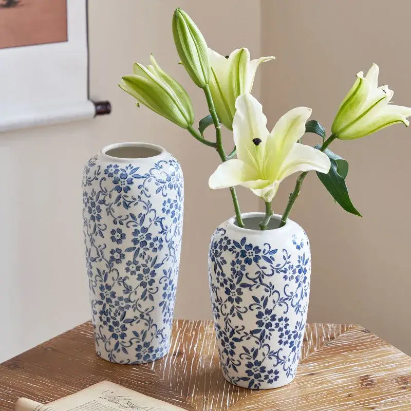 Two blue and white ceramic vases with floral patterns and light green lily buds for decorbites blue living room decor