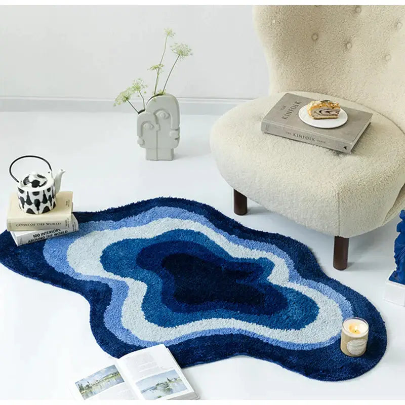 A decorbites cloud shaped tufted non slip bath mat with concentric navy, medium, and light blue rings