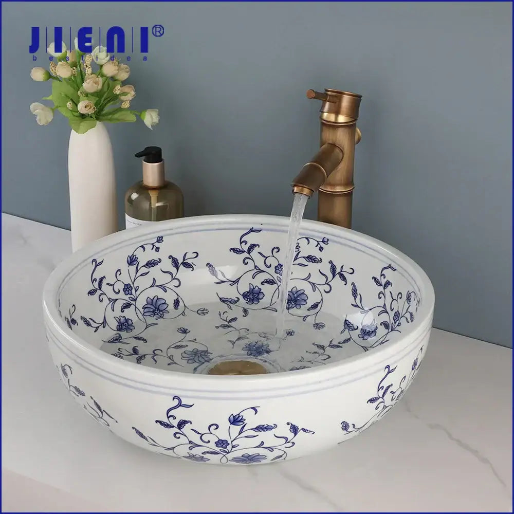 White porcelain basin set featuring intricate blue floral patterns with a pop drain for bathroom use