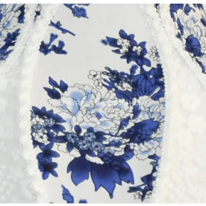 A delicate white lace porcelain floral lampshade with elegant blue pattern and pearl tassel bedroom decor