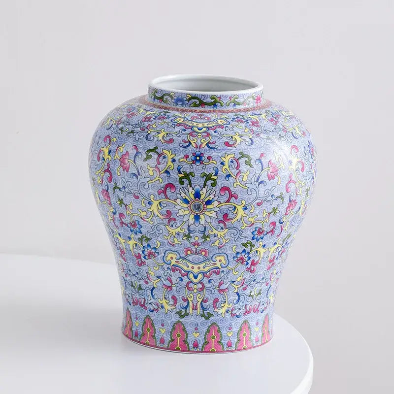 A blue white porcelain floral vase with a light blue base and intricate pink yellow green and gold decorbites patterns for living room decor