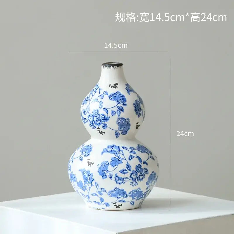 A white porcelain gourd teapot vase with intricate blue floral patterns and a black rimmed opening for living room decor