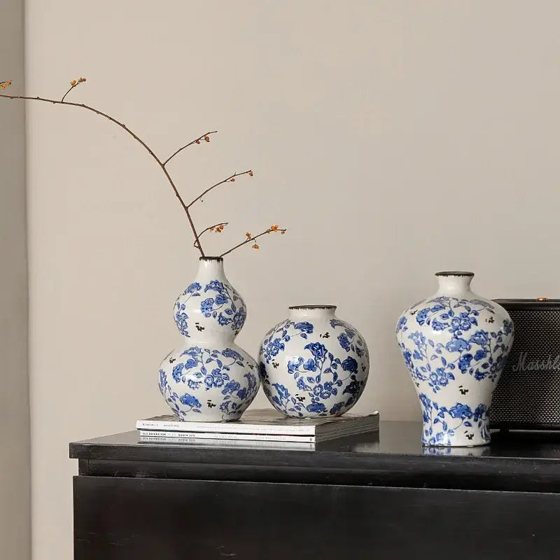Three elegant blue and white porcelain gourd teapot vases with floral patterns for living room decor