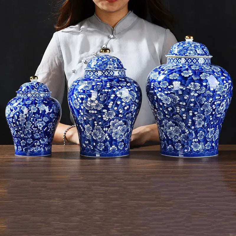 Three blue and white porcelain ginger jars with gold-tipped lids and floral patterns for pot sealed storage tank use