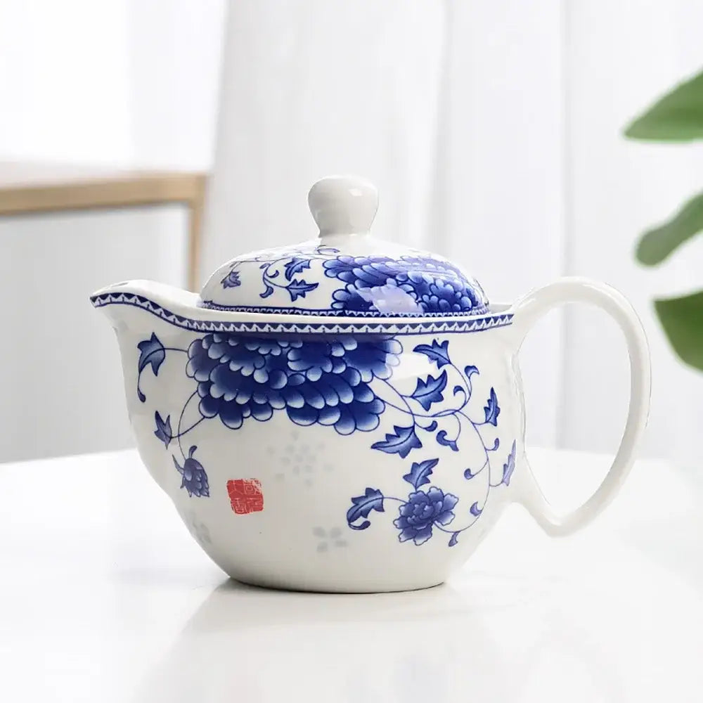 White porcelain tea pot set featuring intricate blue floral patterns and a matching lid with red seal mark