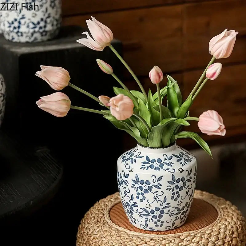 A white porcelain vase with blue floral patterns holding pink tulips for decorbites blue white living room decor