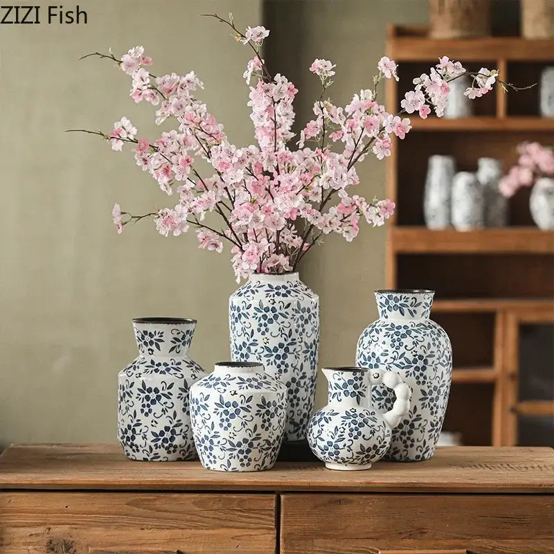 A white porcelain vase with blue floral patterns from decorbites blue white porcelain holds pink cherry blossoms