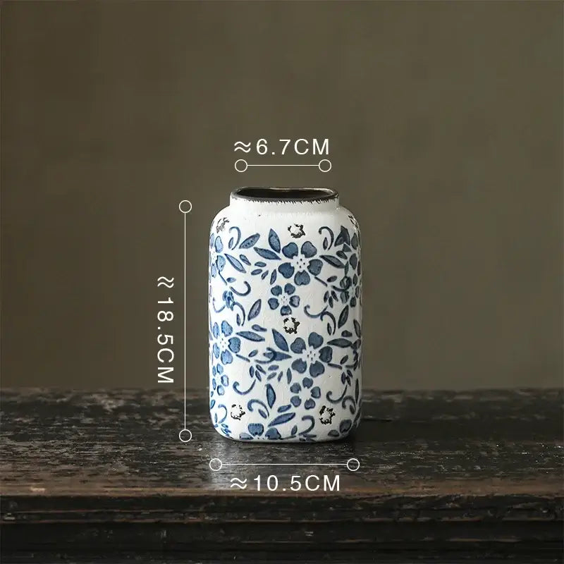 A white porcelain vase with blue floral patterns and a chipped black rim for hydroponic living room decorbites blue white