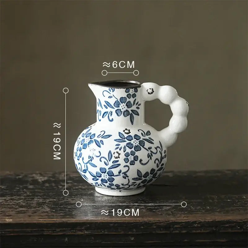 A white porcelain vase with a blue floral pattern and textured bulbous handle for decorbites blue white decor