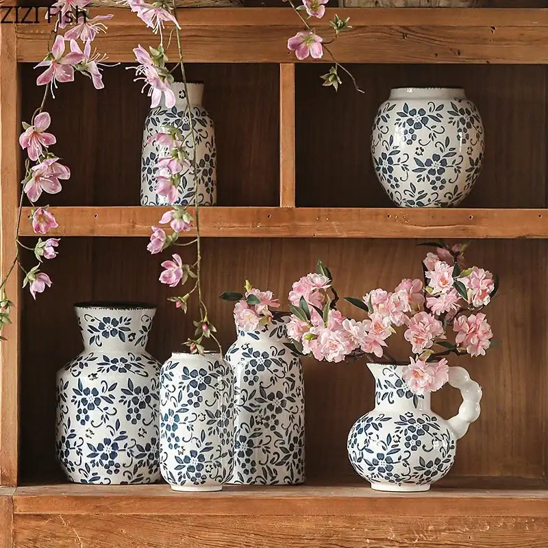 A white porcelain vase with blue white porcelain floral pattern and curved handle filled with pink blossoms for decorbites blue white hydroponic living room decor