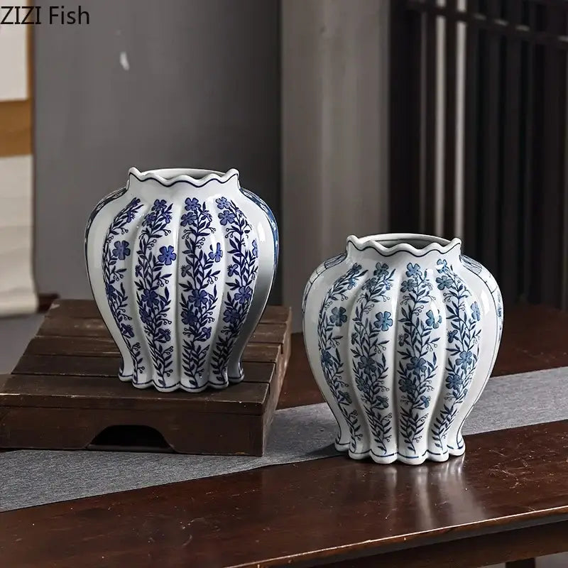 Two elegant white porcelain vases with blue floral patterns and artificial flowers for desk decor