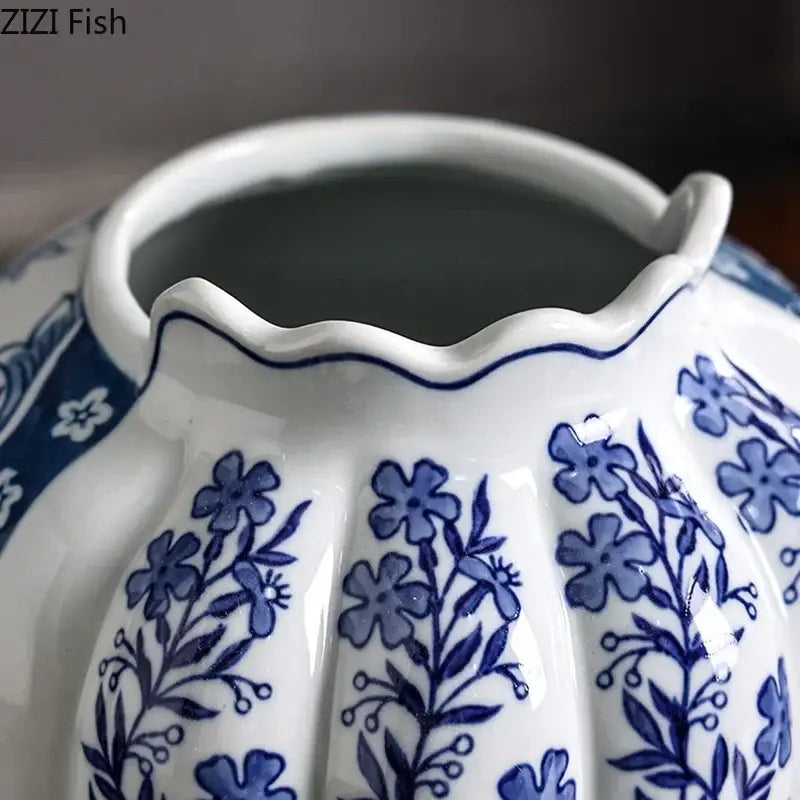 A white porcelain vase with scalloped rim and blue floral patterns in a porcelain vase desk set with artificial flowers