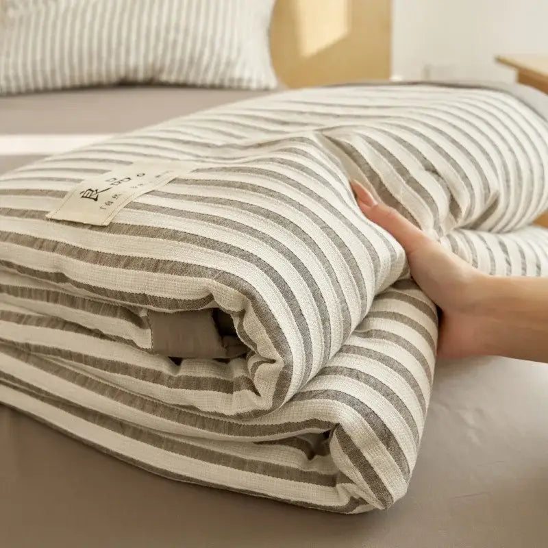 A soft blue and white striped soya fibre jacquard summer quilt folded for bedroom comfort and decorbites jacquard summer use