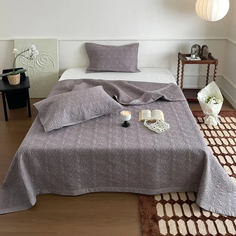 Gray decorbites cotton quilted bedspread with subtle texture draped over bed from blush pink cotton quilted bedspread set