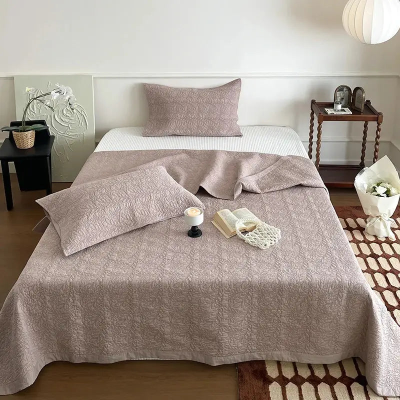Soft mauve cotton quilted bedspread set with subtle texture draped over a neatly made bed for bedroom decorbites cotton quilted