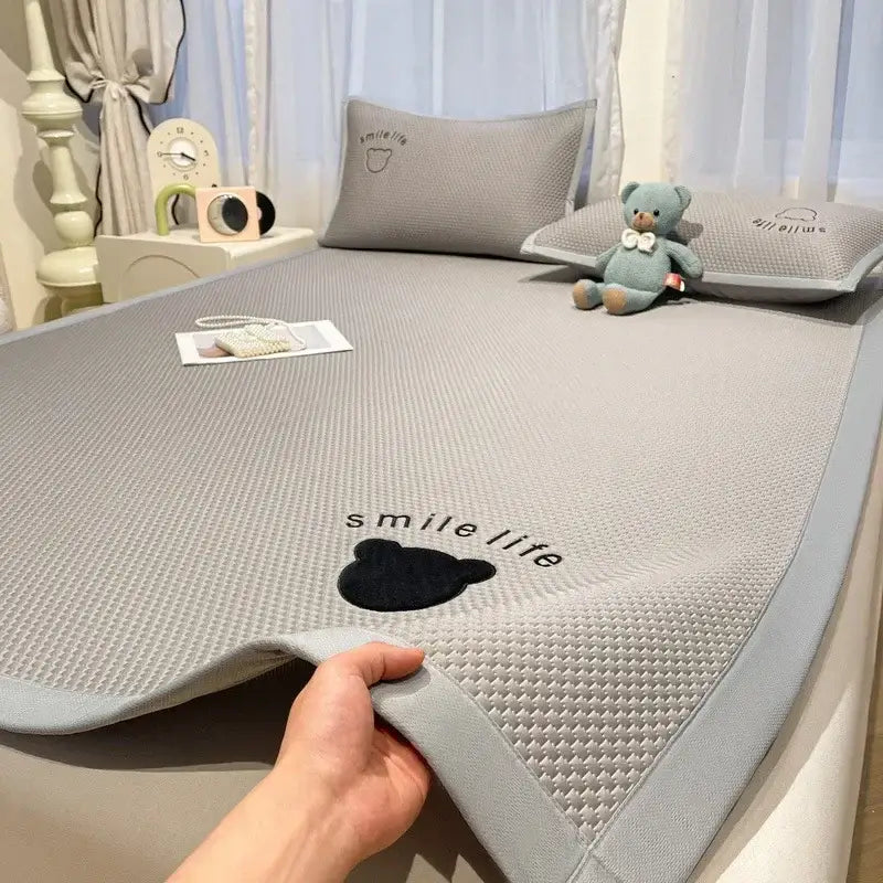 Gray textured cooling mattress pad with black embroidered bear and smile life text in blush pink diamond jacquard cooling bed sheet set