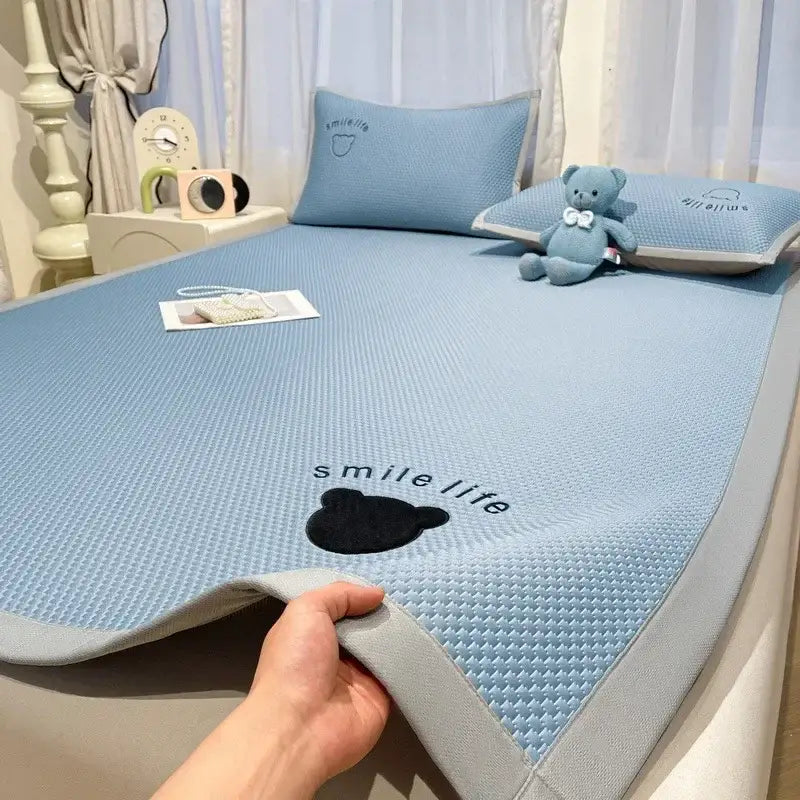 Light blue textured cooling mattress pad with gray border and bear design complementing blush pink cooling bed sheet set