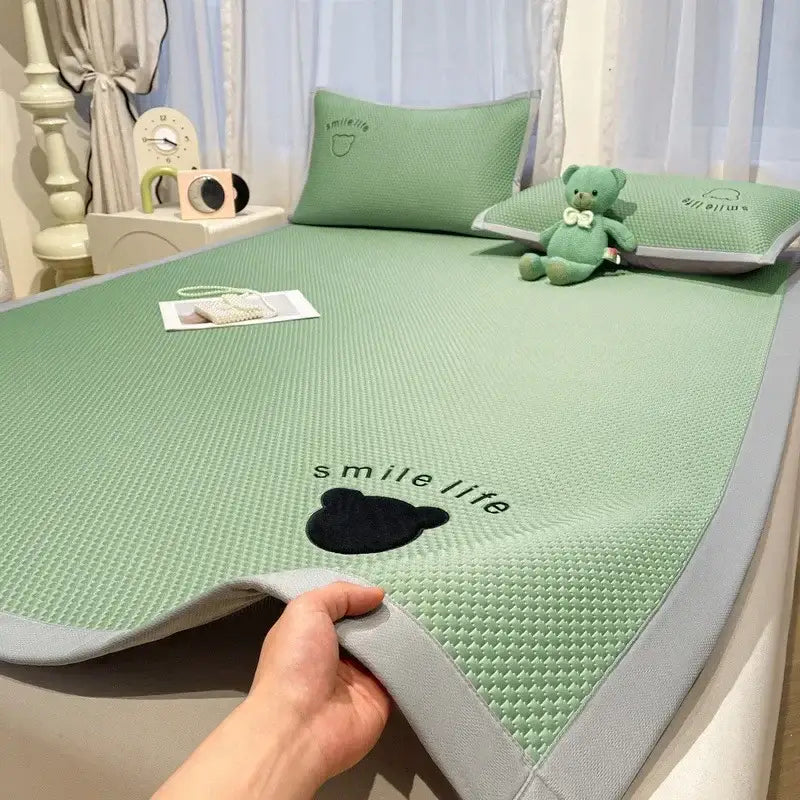 Light green textured cooling mattress pad with gray border and black bear design complementing blush pink cooling bed sheet set