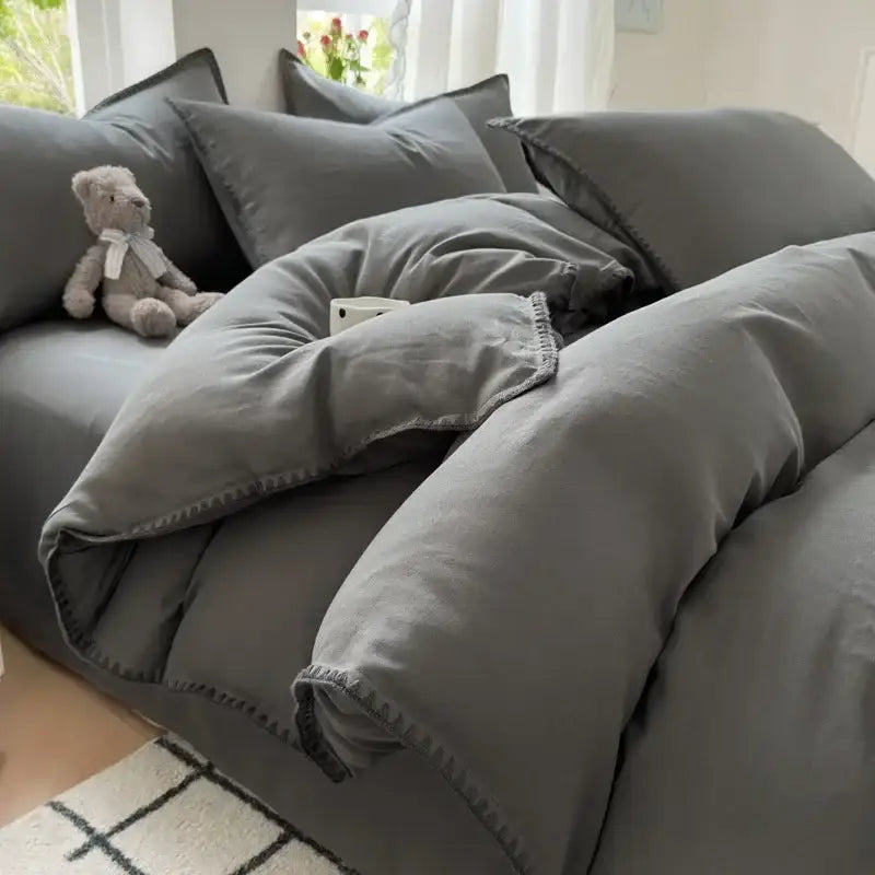 Gray quilted cotton bedding set with stitched edges and matching pillows in blush pink and gray cotton bedding set