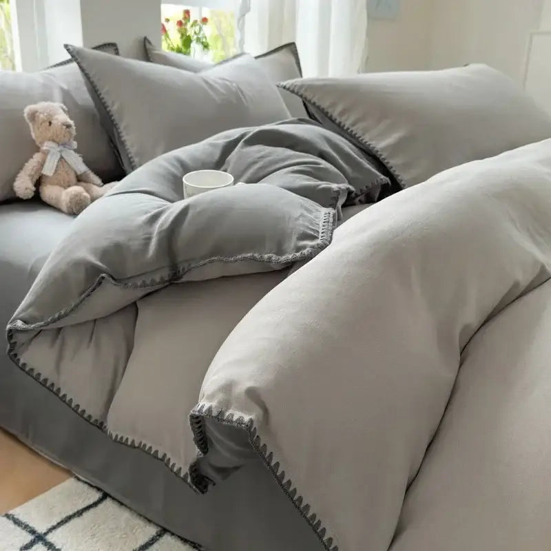 Gray linen duvet set featuring a subtle zigzag stitch trim in a blush pink and gray cotton bedding set